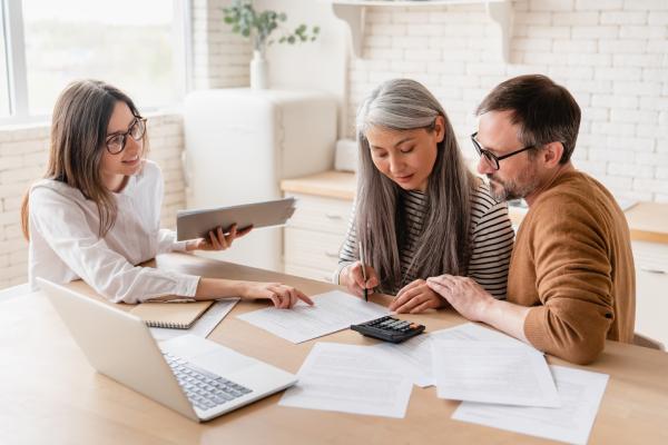 A couple sign a contract during a consultation with a professional female lawyer